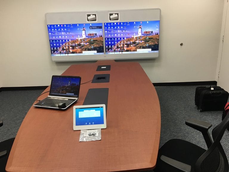 Conference room with medium size dual display video conference system at the end of the table.