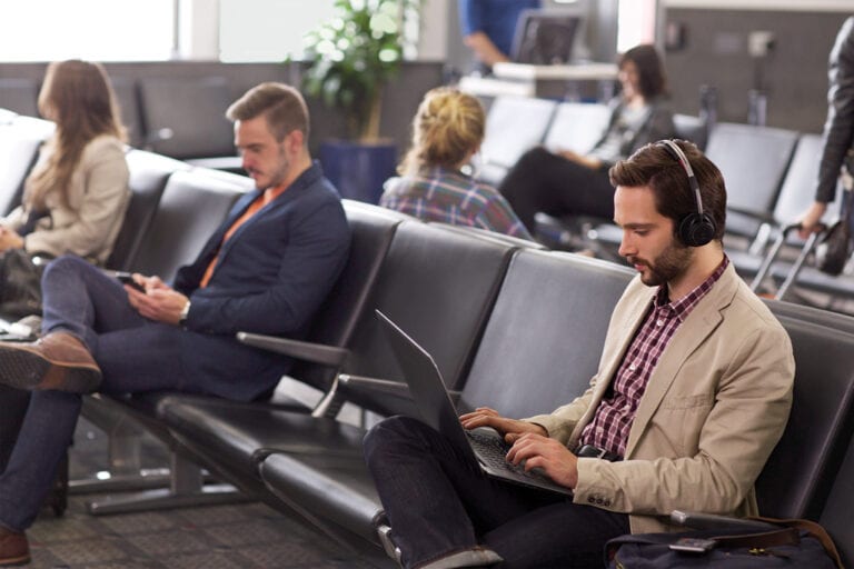 Man Working Remotely at an Airport with Poly Voyager